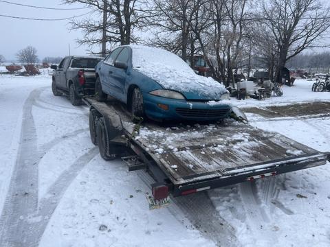 GetMyScrapCar | Snow-Covered Junk Car on Trailer for Scrap Metal Recycling