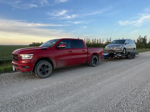 GetMyScrapCar | Red Truck Towing a Junk Car for Scrap Metal Recycling