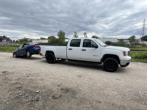 GetMyScrapCar | White Pickup Truck Towing a Junk Car for Scrap Metal Recycling